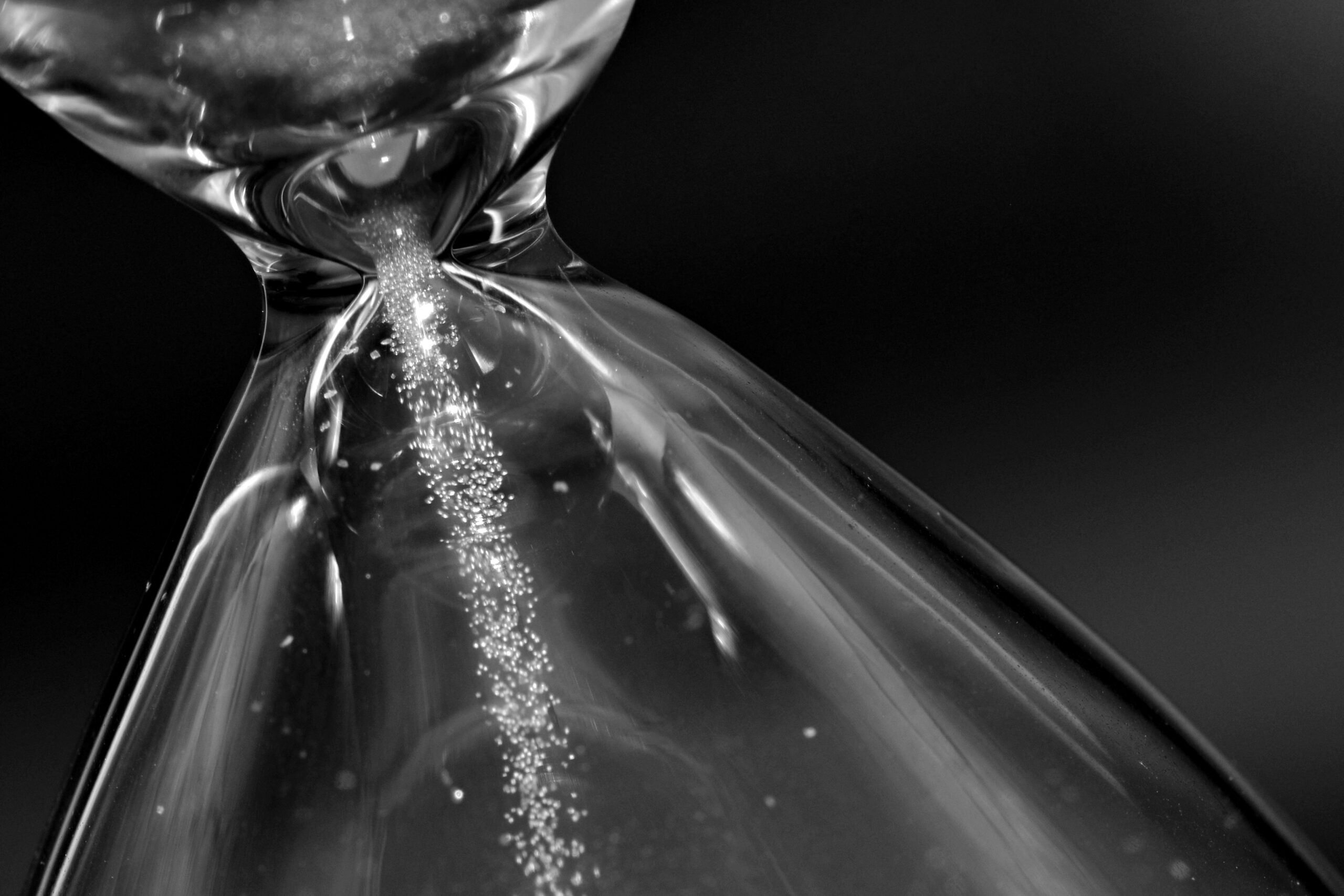 Detalle de un reloj de arena verde contando el tiempo